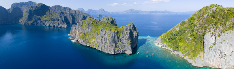 Surrounded by coral, rugged limestone islands rise from Bacuit Bay, El Nido. This area in the Philippines is a popular vacation destination due to its coral reefs, beaches, and limestone islands. © ead72
