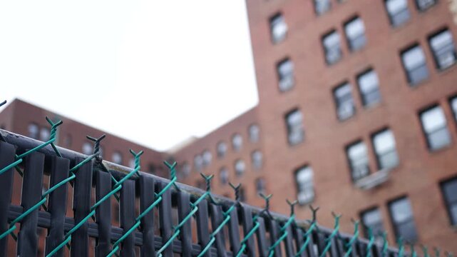Establishing Shot of Blurry Building with Perimeter Fence in Foreground