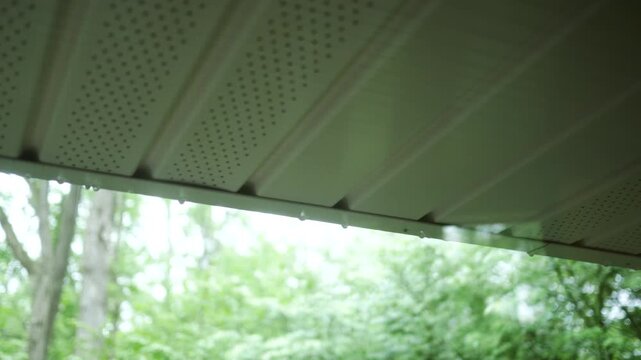 Raindrops Falling over Soffit From Full Gutter in Residential Home