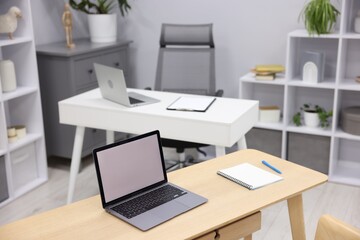 Fototapeta premium Desks with laptops, stationery, other furniture and decor. Interior design