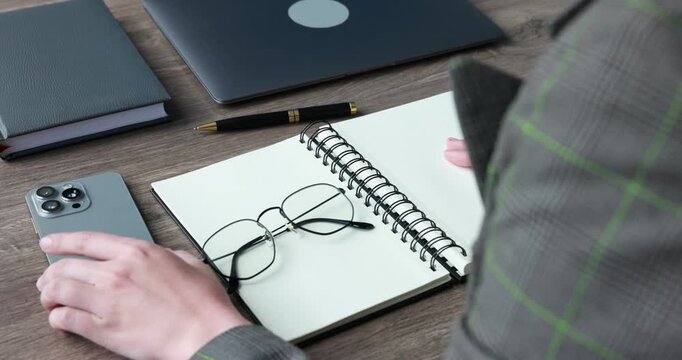 Businesswoman arranging stylish glasses and office supplies at wooden table, closeup