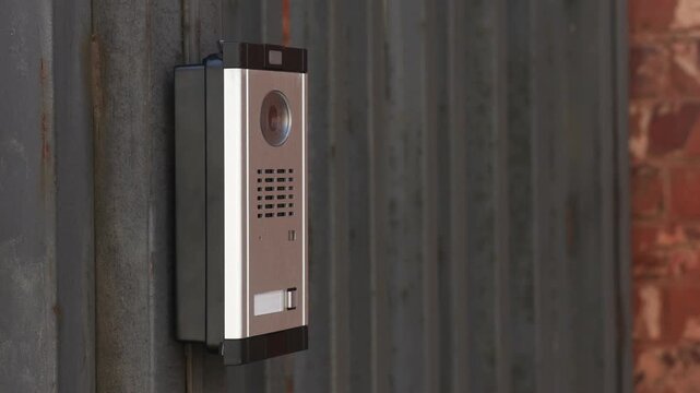 Modern intercom system on gate outdoors, closeup. Camera moving right