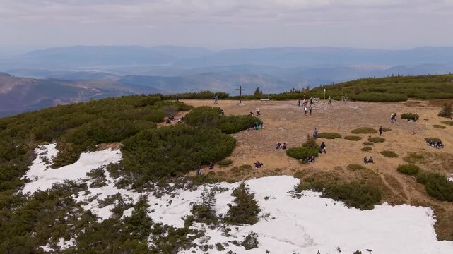 Aerial drone view of Pilsko mountain summit with hikers and snow patches