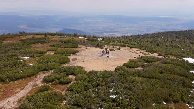 Aerial drone view of Pilsko mountain summit with hikers and snow patches