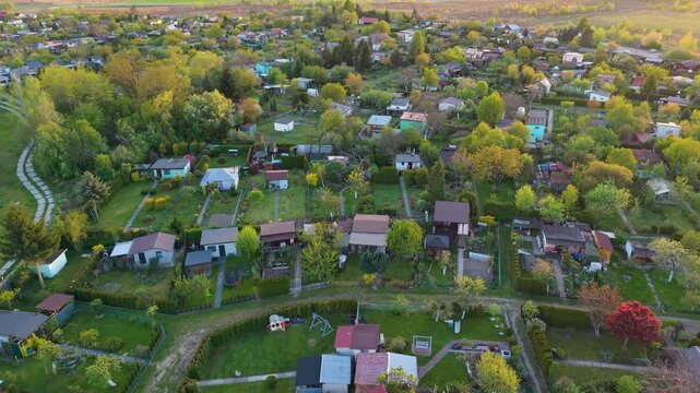 Aerial drone view of recreational garden plots with small cottages and greenery
