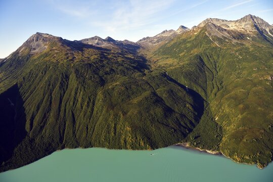 Steep forested mountainsides and an emerald green lake, Lake Clark National Park, Alaska, USA