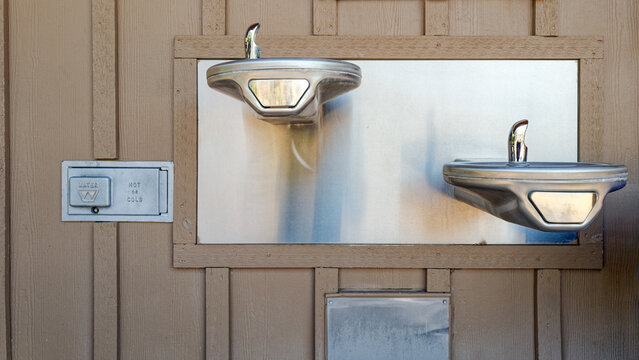 Drinking fountains at different heights for children and adults are installed on an exterior wall