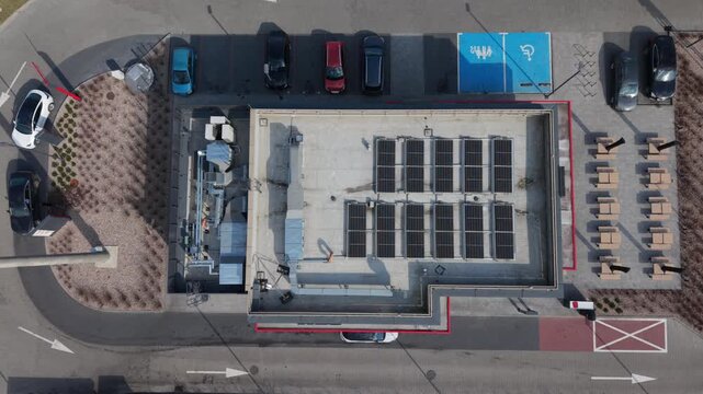 Drone Rooftop Cafe Solar Panels Installed Over Neighborhood Storefront, Accessible Parking Bay, Outdoor Seating, Car Stalls, Crew Absent, Morning Light, Sustainable Business Branding, Clean