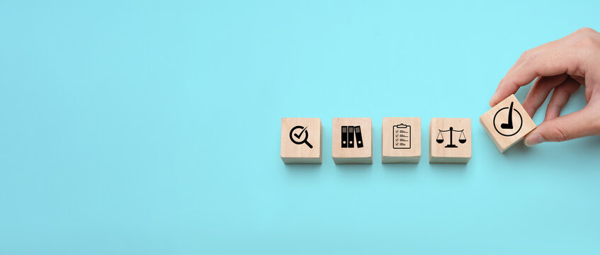 Business compliance audit and regulatory verification concept with hand placing approval block among quality control icons representing inspection, documentation, governance and legal standards