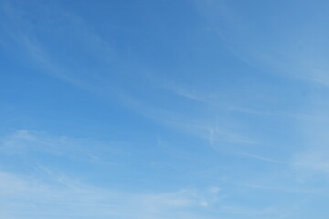 Obraz premium The vast expanse of clear blue sky dotted with thin, fluffy white clouds offers a serene and open backdrop for a variety of design needs.