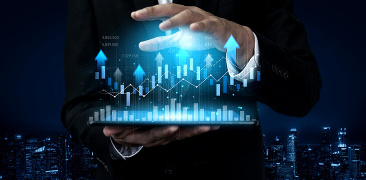 A professional holding a tablet displaying dynamic financial graphs and upward arrows, symbolizing investment growth and analysis in a modern city at night. Scalp