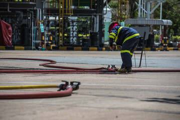 Fototapeta premium Firefighters practiced responding to fires in buildings and oil depots using water and foam.