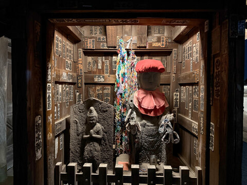 Illuminated Jizo statue and stone deity at night, Tennoji Temple in Yanaka, Tokyo