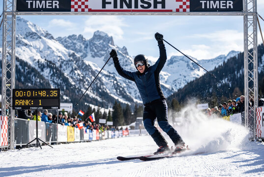 Excited Skier Celebrating Victory at Alpine Finish Line with Spectators Cheering in Background
