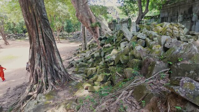 Ancient stone ruins of Beng Mealea temple, Cambodia, overgrown with trees and scattered with large rocks, showcasing the jungle's reclamation of the historic site.