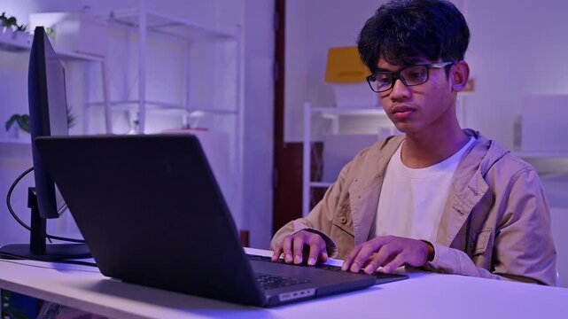 Focused Male Freelancer Wear Glasses Write Code On Laptop In Purple Room