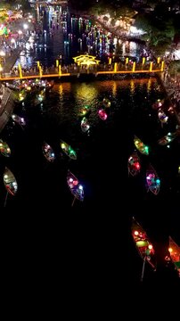 Panorama aerial drone view of Hoi An ancient town with boat tour and beautiful lanterns in night. UNESCO world heritage. One of the most travel popular touristic destinations