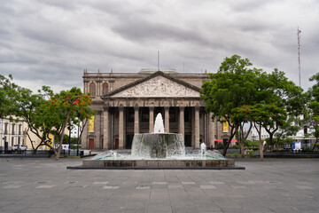 Fototapeta premium Fachada del Histórico Teatro Degollado de Guadalajara y fuente de agua de la Plaza de la Liberación.