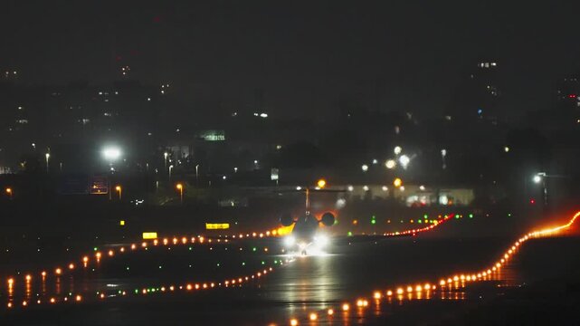 Small corporate business jet moving along a dark airport runway guided by bright glowing navigation lights