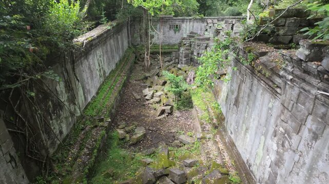 Beng Mealea temple ruins in Cambodia, overgrown with moss and jungle. The ancient stone structures are scattered and reclaimed by nature.