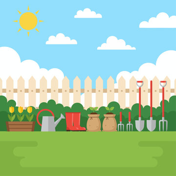 Gardening tools and supplies arranged outdoors on green lawn beside white picket fence under sunny sky