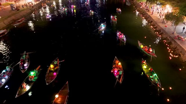 Panorama aerial drone view of Hoi An ancient town with boat tour and beautiful lanterns in night. UNESCO world heritage. One of the most travel popular touristic destinations
