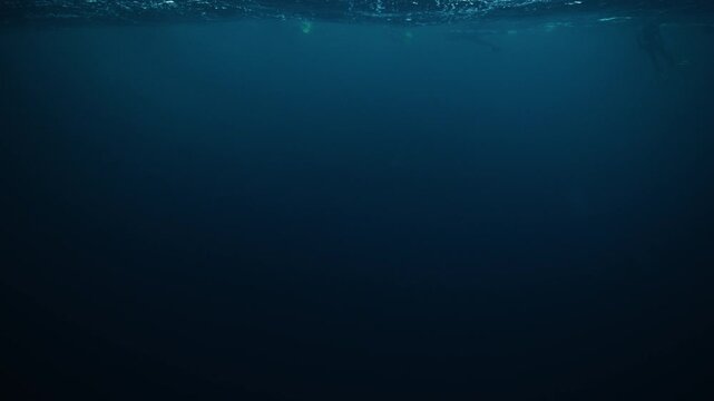 Dark Arctic underwater gradient beneath rippling Norway ocean surface texture