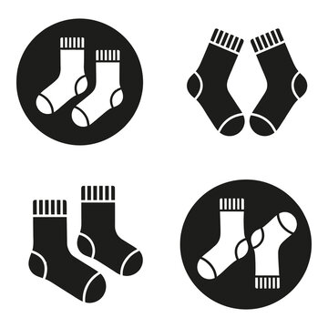 Four pairs of socks in different colors and circular designs on white background icon