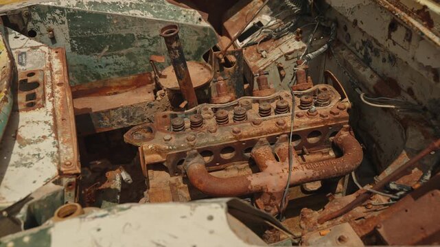 Closeup of heavily rusted vintage engine block exposed inside abandoned truck wreck in southern Moroccan desert