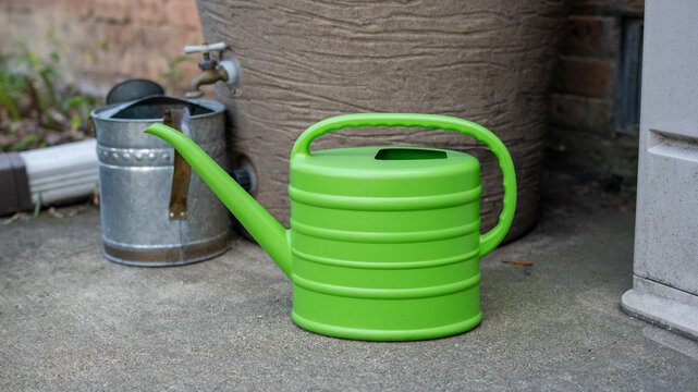 Bright Light Green Plastic Gardening Watering Can on Rustic Background