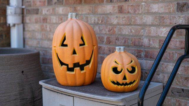 Plastic Halloween Jack O'Lanterns Against Brick Wall Background