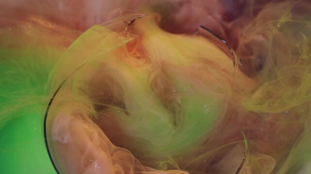 Paint blend. Underwater smoke. Defocused orange green yellow color glitter broken glass cloud fog splash spreading on abstract background.