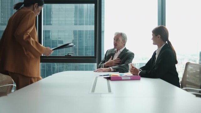 White senior male CEO boss interviews Asian female worker for company employment collaboration and job opportunity with career resume document in office meeting with human resources secretary woman.