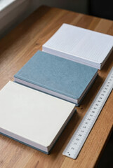 Fototapeta premium A pile of new notebooks in squares and lines, neatly stacked on desks, realistic lighting, sharp and detailed image