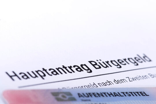 Antrag auf B&uuml;rgergeld und Dokument Aufenthaltstitel als Symbol f&uuml;r die Zahlungen von Sozialleistungen an ausl&auml;ndische B&uuml;rger in Deutschland