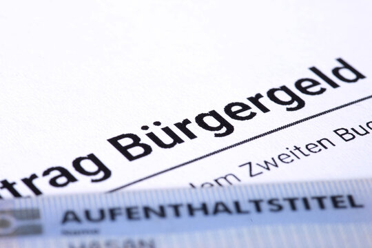 Antrag auf B&uuml;rgergeld und Dokument Aufenthaltstitel als Symbol f&uuml;r die Zahlungen von Sozialleistungen an ausl&auml;ndische B&uuml;rger in Deutschland