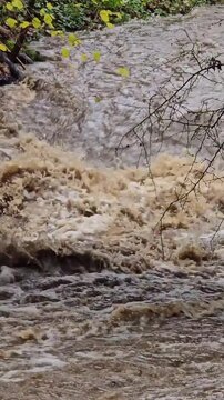 Raging muddy river water flowing violently