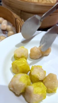Serving Fresh Dim Sum Shumai and Har Gow from Bamboo Steamer