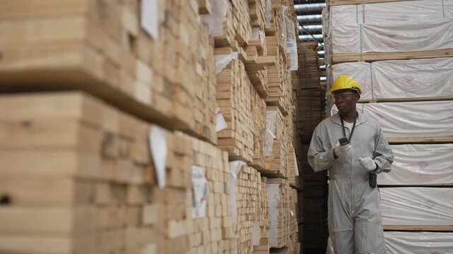 Inspector Examining Stacked Timber Pallets at Lumber Warehouse
