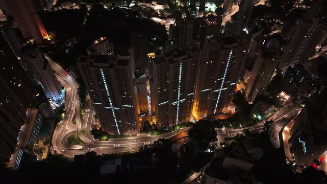 Drone night view of Hong Kong skyscrapers and winding roads
