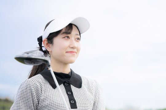 ゴルフ練習場で上達や成功を喜ぶ 見上げる女性の笑顔 スポーツライフスタイルイメージ　