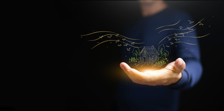 A man holding glowing rural home drawing with trees and birds on dark copy space. Deurbanization, countryside living, migration, nature, remote work, housing shift, and sustainable lifestyle concept.