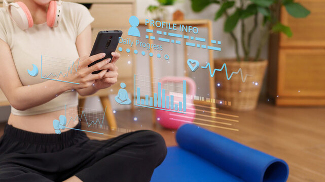 Asian women using smartphone mobile app tracking fitness health data profile heart rate daily progress exercise workout activity sitting yoga mat home with