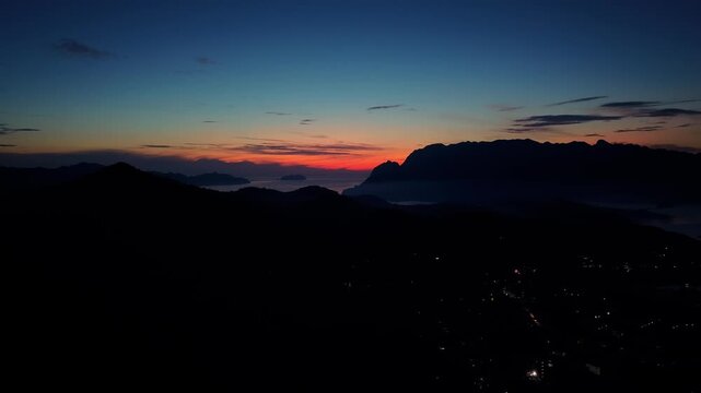 Sunrise time lapse from Mount Tapyas in Coron Palawan Philippines looking toward island silhouettes coastal hills soft blue sky and early morning light