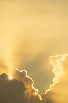 Dramatic clouds at sunset. Thick, golden clouds illuminated by soft, warm sunlight.