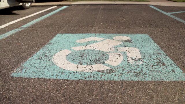 Wheelchair Handicap Accessibility Symbol Painted on Asphalt Pavement