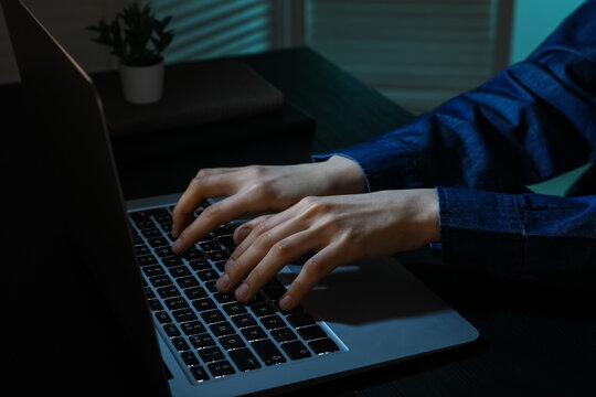Professional programmer using laptop at table in office, closeup