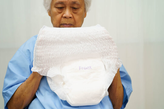 Asian senior woman patient wearing adult incontinence diaper pad in hospital.