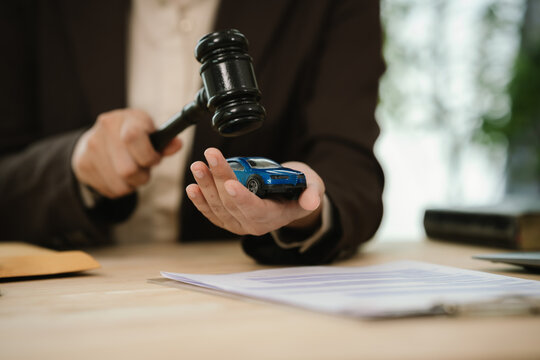 Judge&rsquo;s gavel above a model car, symbolizing auto insurance claims, legal disputes, vehicle liability, compensation, and transportation law.