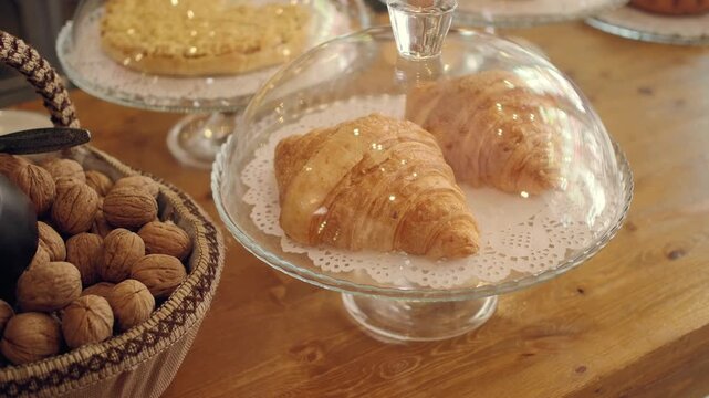 Croissants displayed in bakery with fresh nuts on table